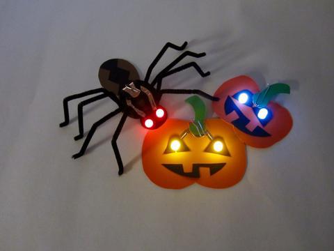 crafted pumpkins and spider with glowing eyes 