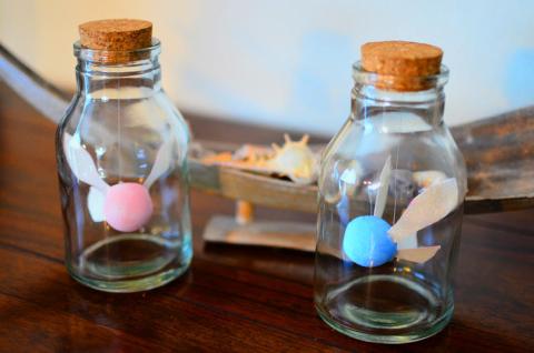 two small glass bottles with cork tops containing fairies reminiscent of those from the legend of zelda 