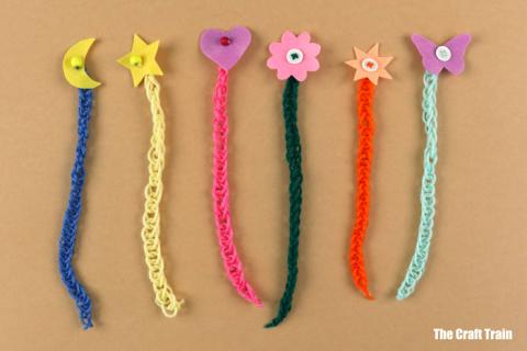 six colorful finger knitted chains with shapes glued on one end to be bookmarks