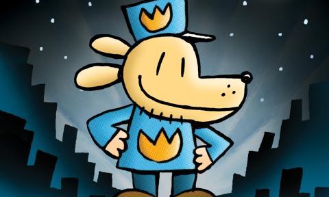 dog man from the cover of the first book. He is light brown with a smiling face looking to the right. He is wearing a blue had and blue shirt and is standing with his hands on his hips in front of a city skyline