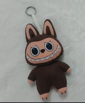 keychain of a brown furry monster with bunny ears, hand-sewn. It is an imitation of the popular Labubu.
