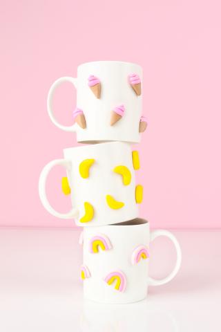photo of three white ceramic mugs with small clay pieces stuck to the surface of each. Photo from Studio DIY blog.