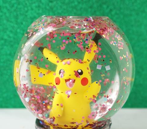 homemade snow globe with pikachu and red glitter inside 