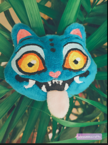 photo of a plush head of a blue tiger with tongue sticking out, a character from K-pop Demon Hunters