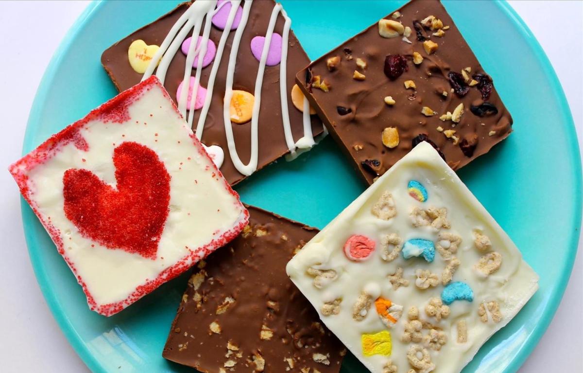 blue plate holding five square chocolate bars with different novelty mix-ins