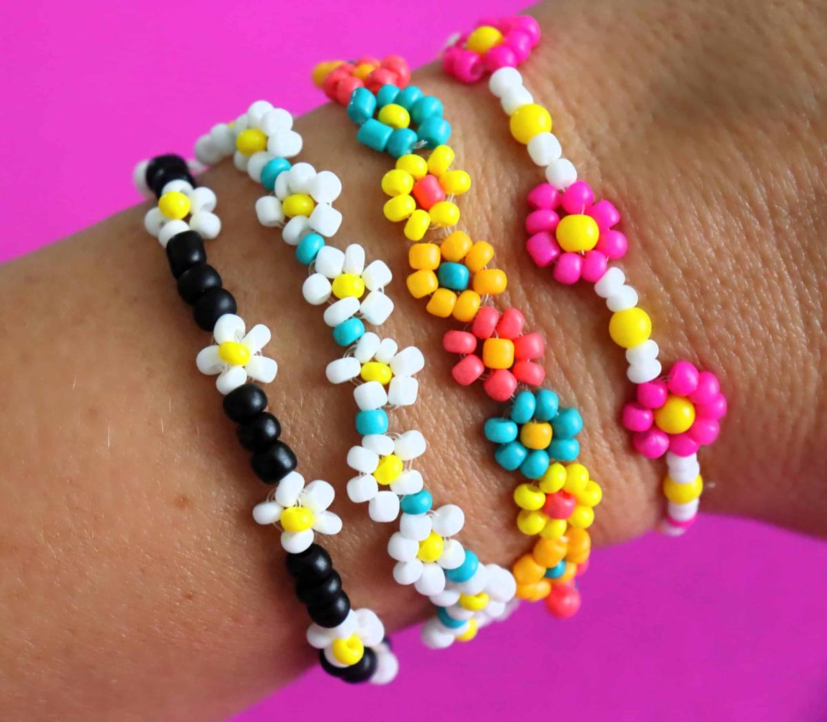 wrist wearing four floral-themed beaded bracelets 